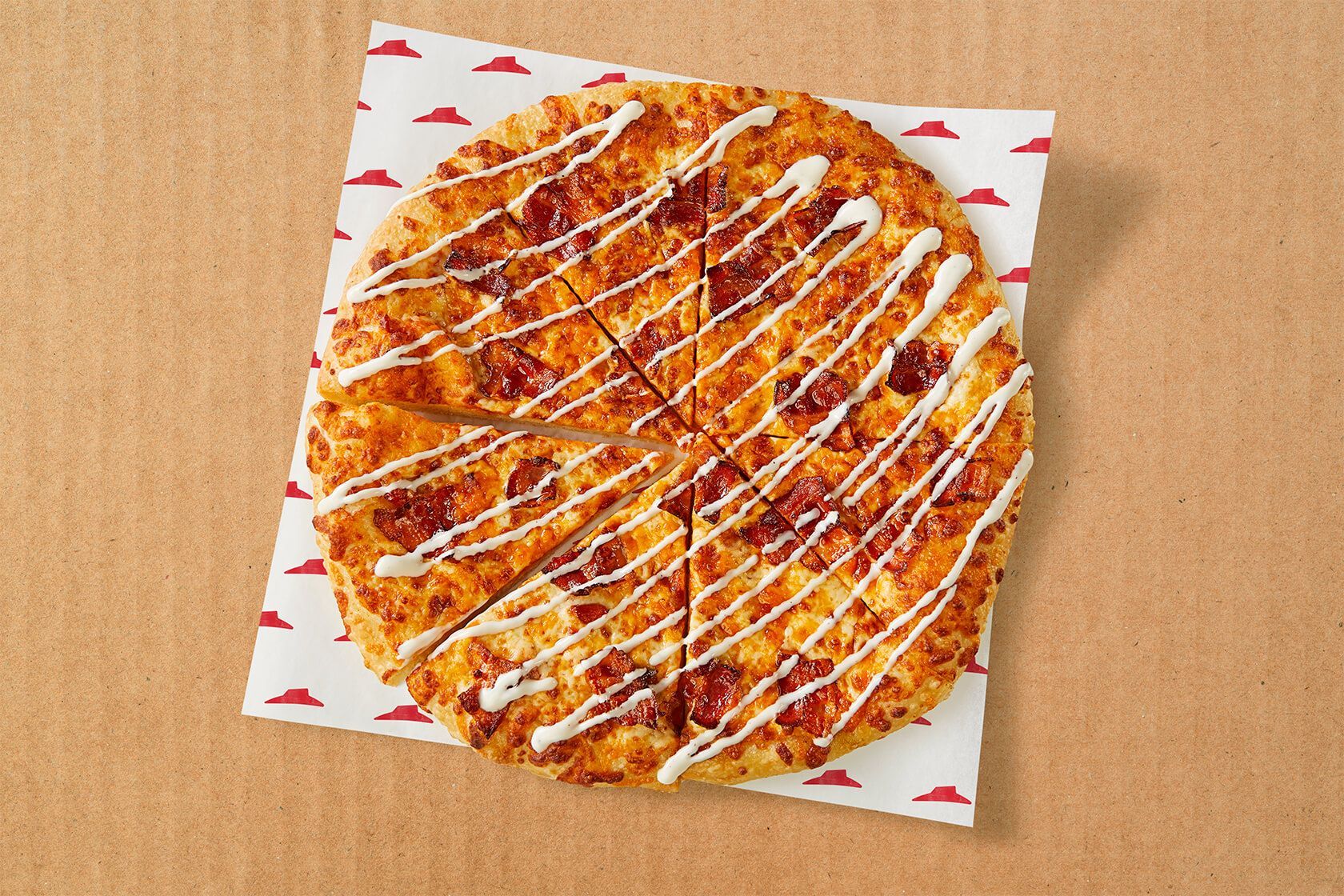 A pizza is sitting on a piece of paper on top of a cardboard box.