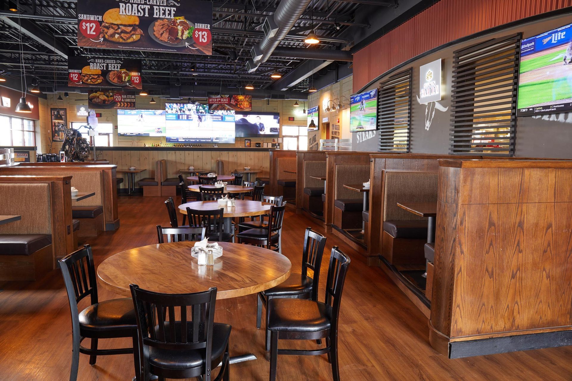 A restaurant with tables and chairs and a sign that says enjoy beef