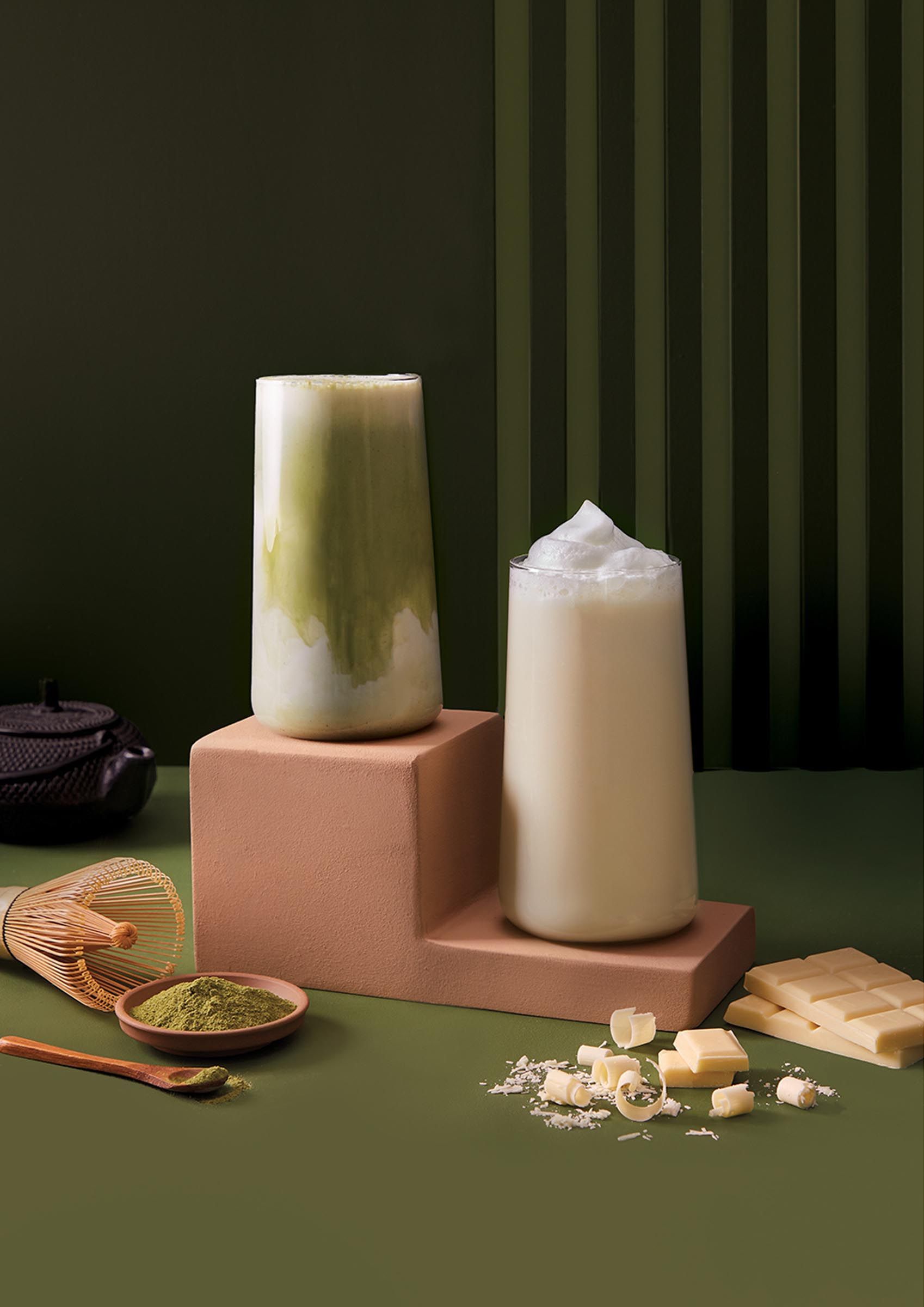 A couple of tall drink glasses sitting on top of a table next to each other.