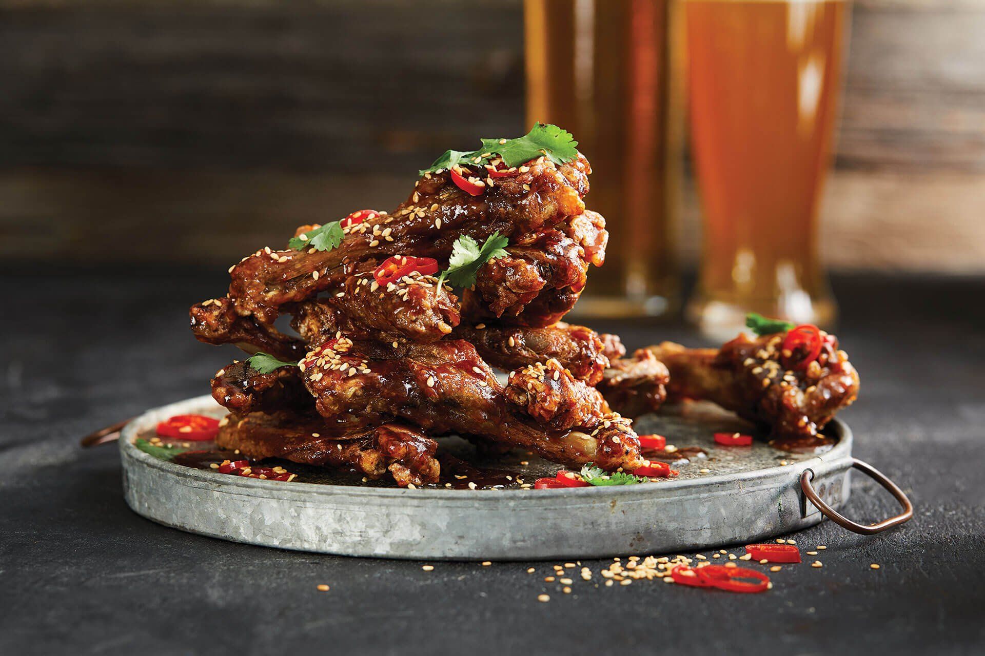 A plate of food with a glass of beer in the background