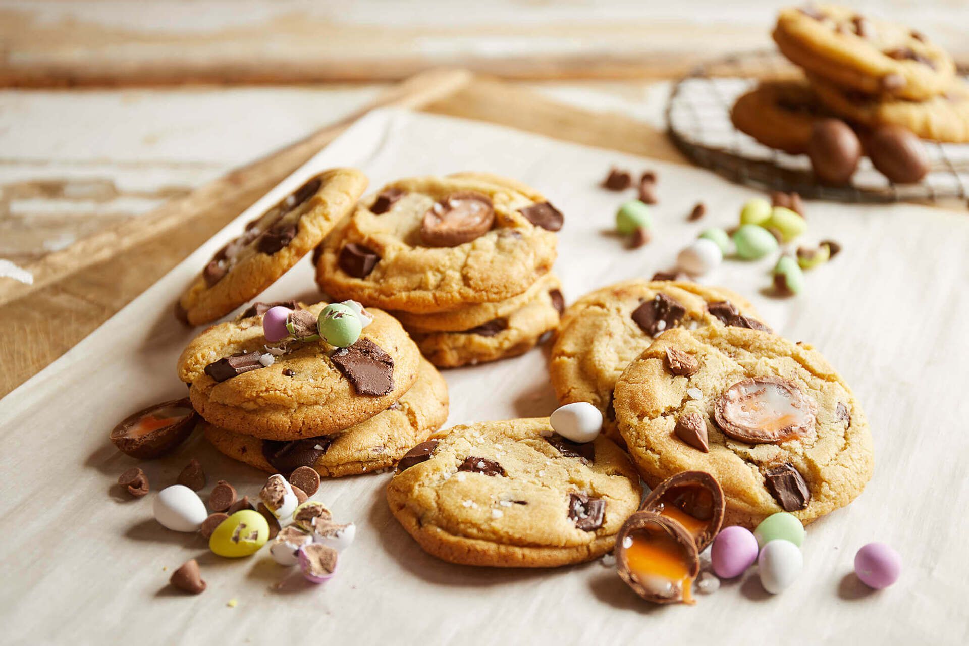 A stack of chocolate chip cookies with easter eggs on a table.