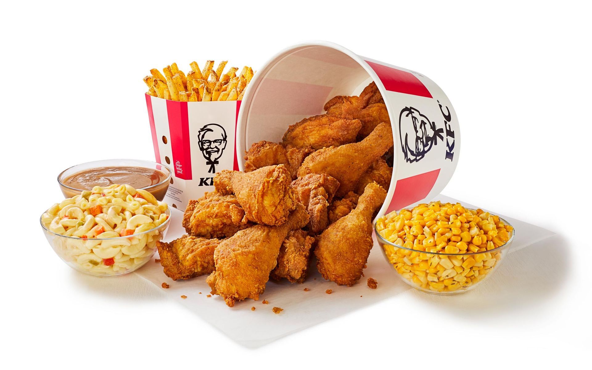 A bucket of fried chicken , french fries , coleslaw and corn on the cob.