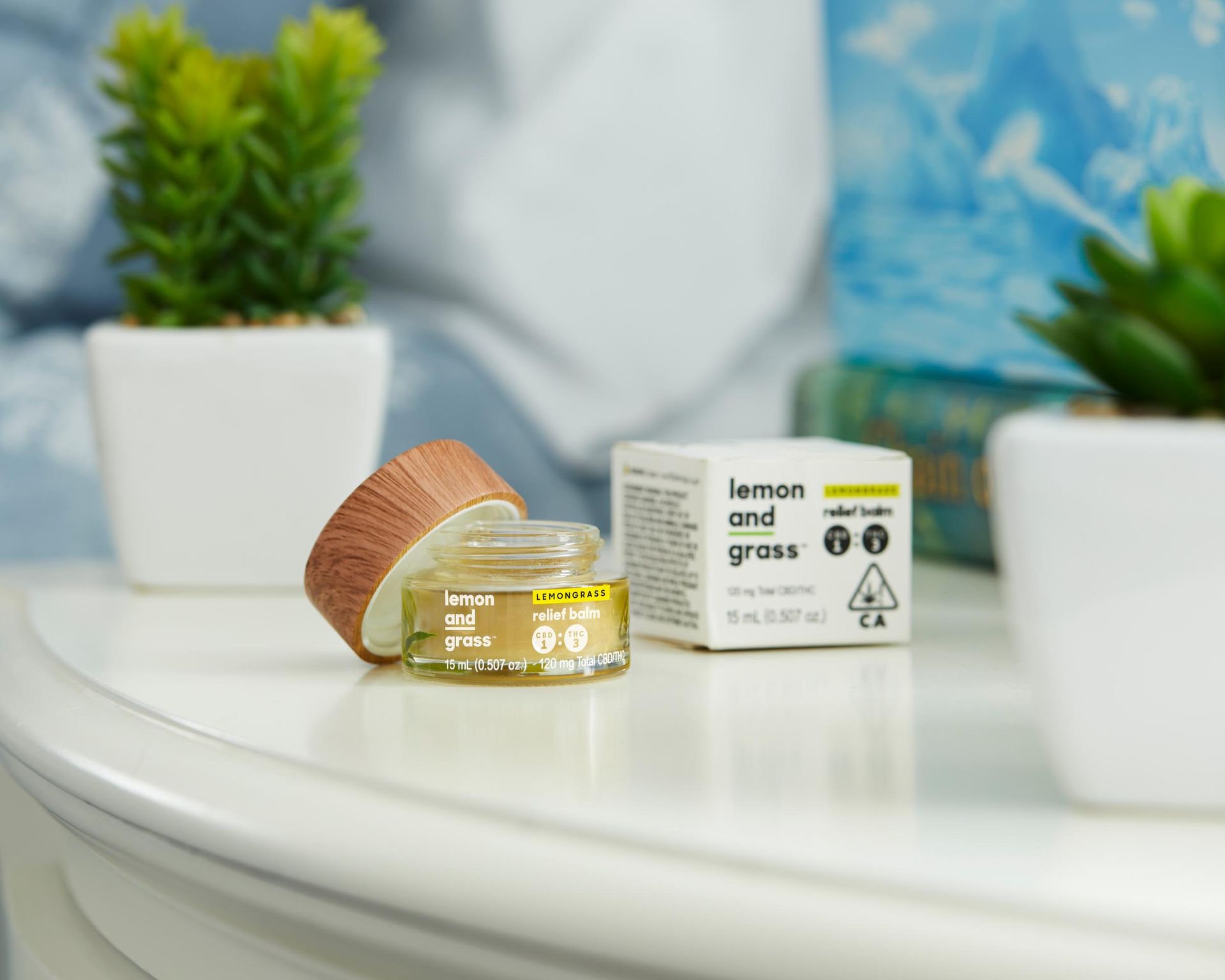A jar of balm sitting on a table next to it's container.