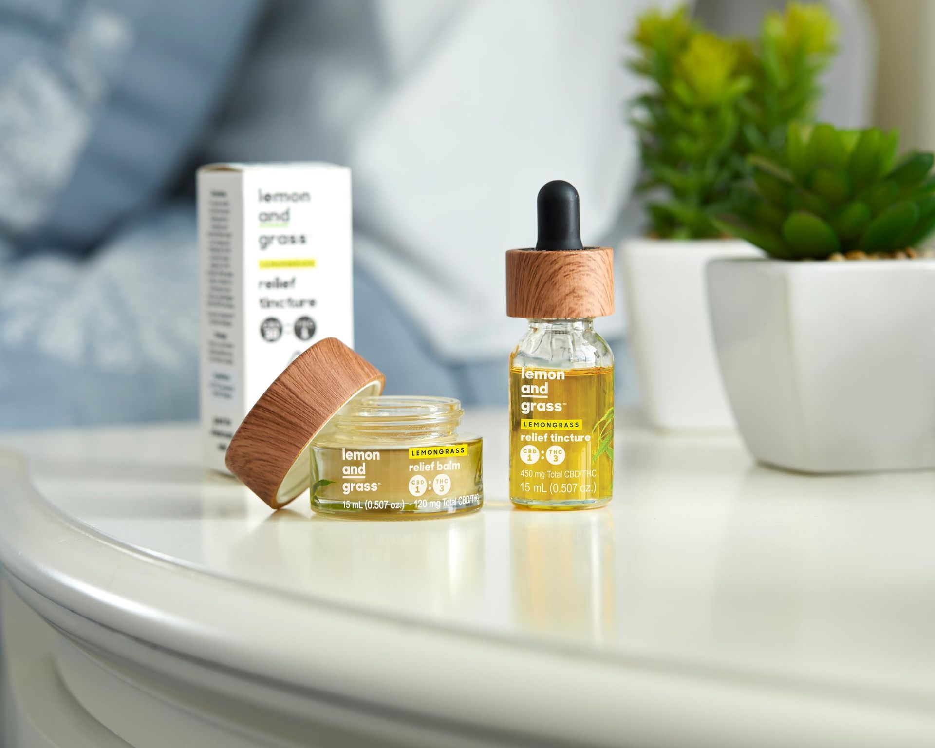 Two bottles of oil are sitting on a table next to a plant.