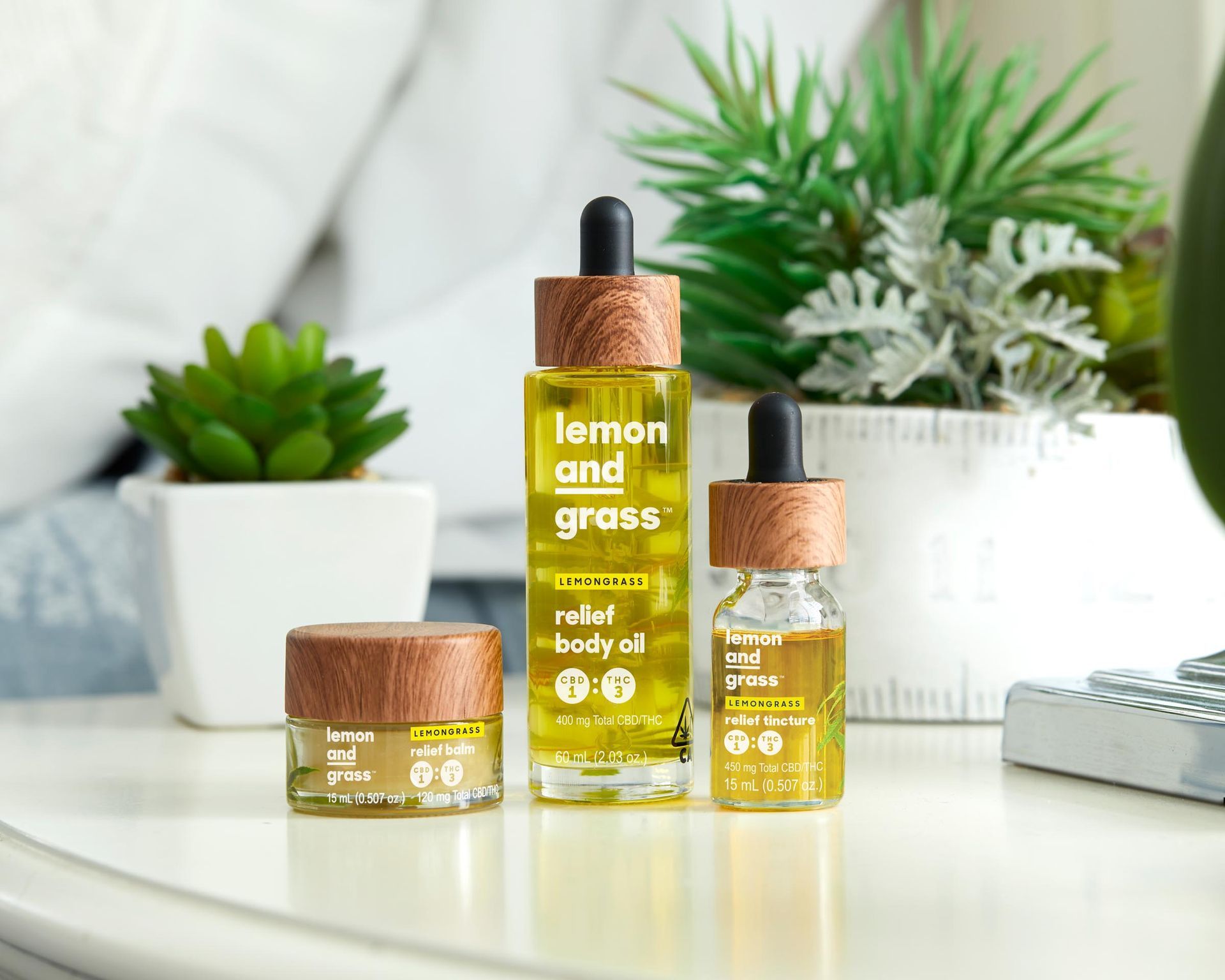 Three bottles of oil are sitting on a table.