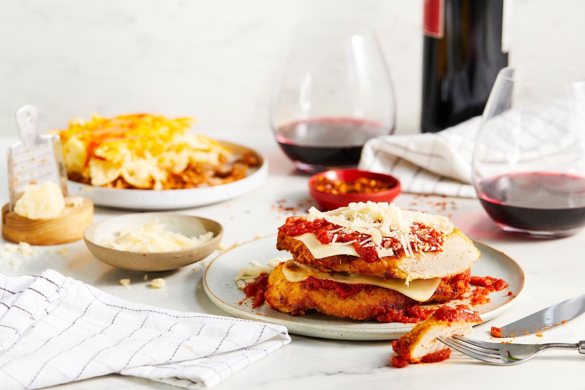 A plate of food is sitting on a table next to a bottle of wine.