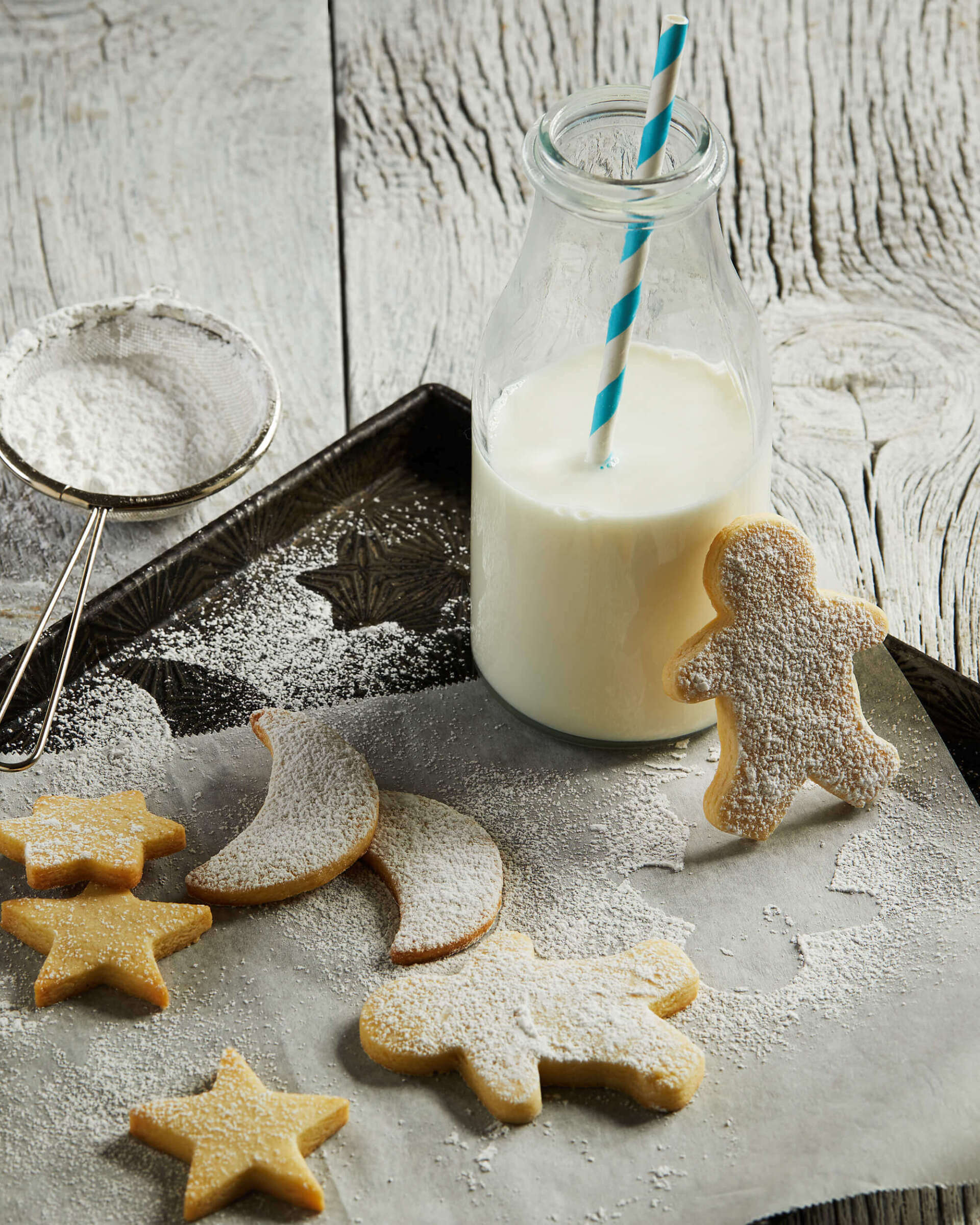 A tray of cookies and a bottle of milk on a table