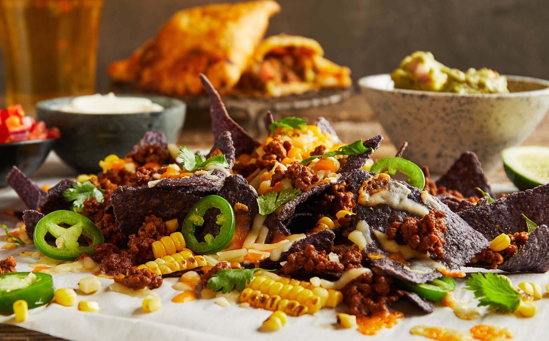 A close up of a plate of nachos on a table.