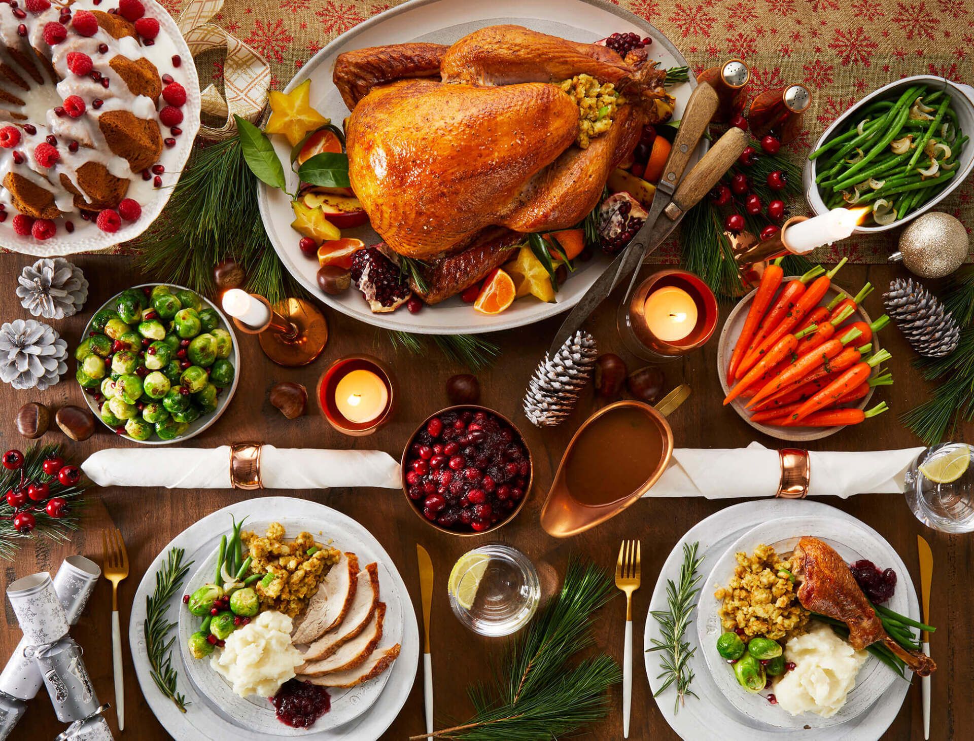 A table topped with plates of food and a turkey.