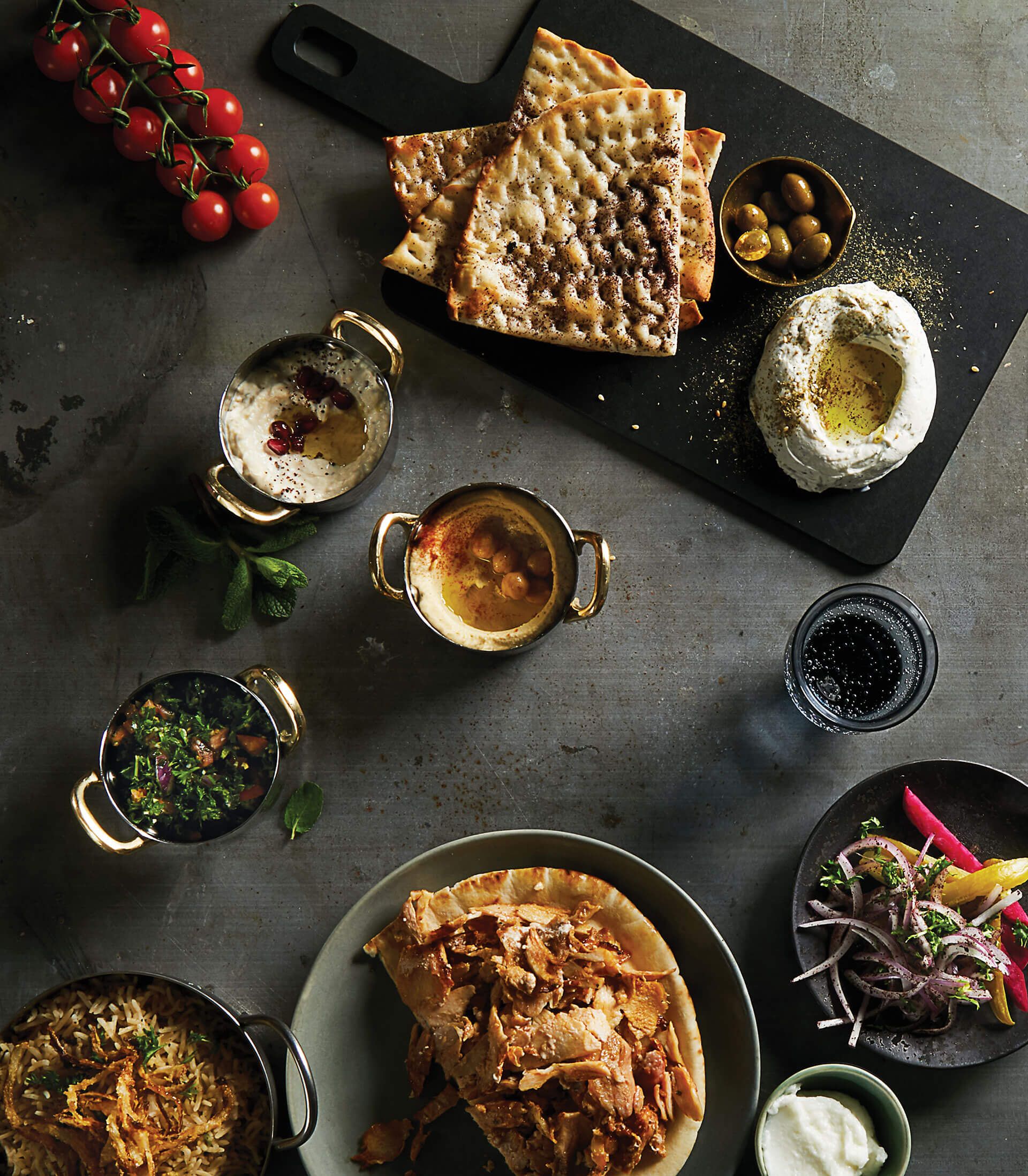 A table topped with plates of food and a cutting board
