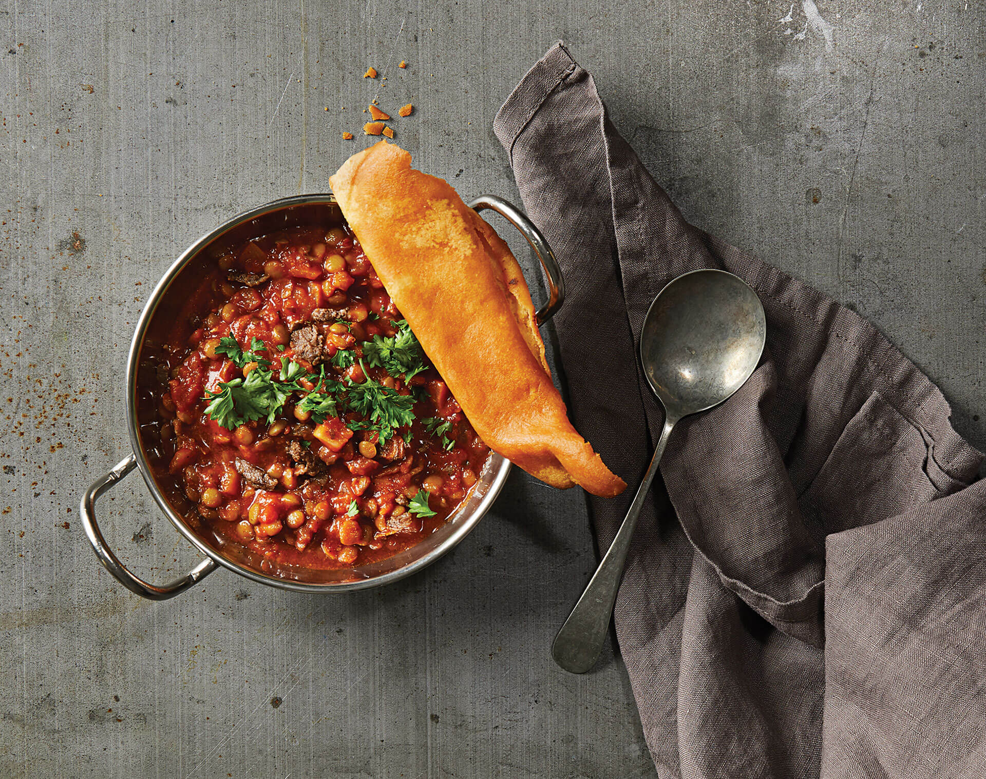 A bowl of food with a piece of bread in it