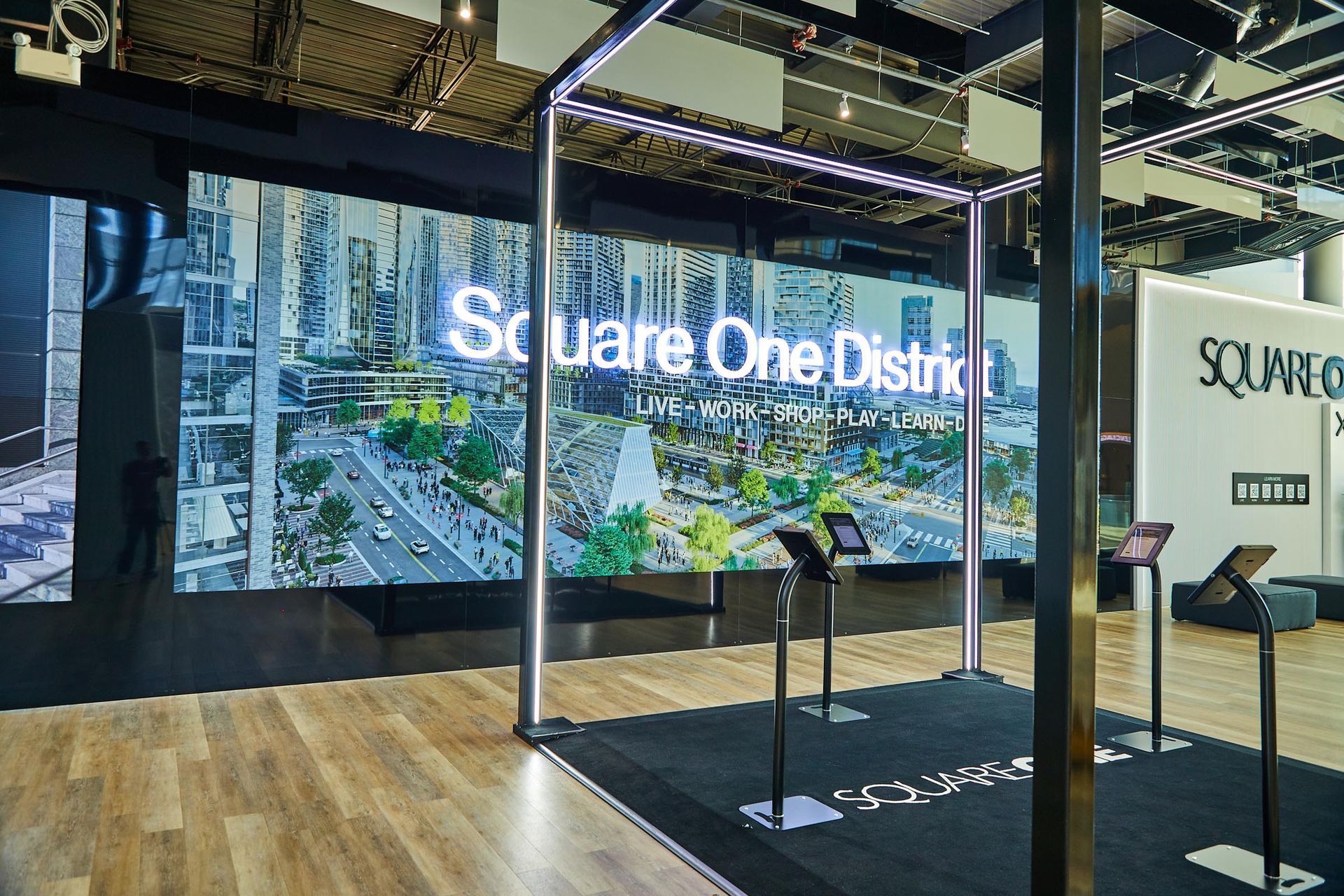 A room with a large screen that says square one district