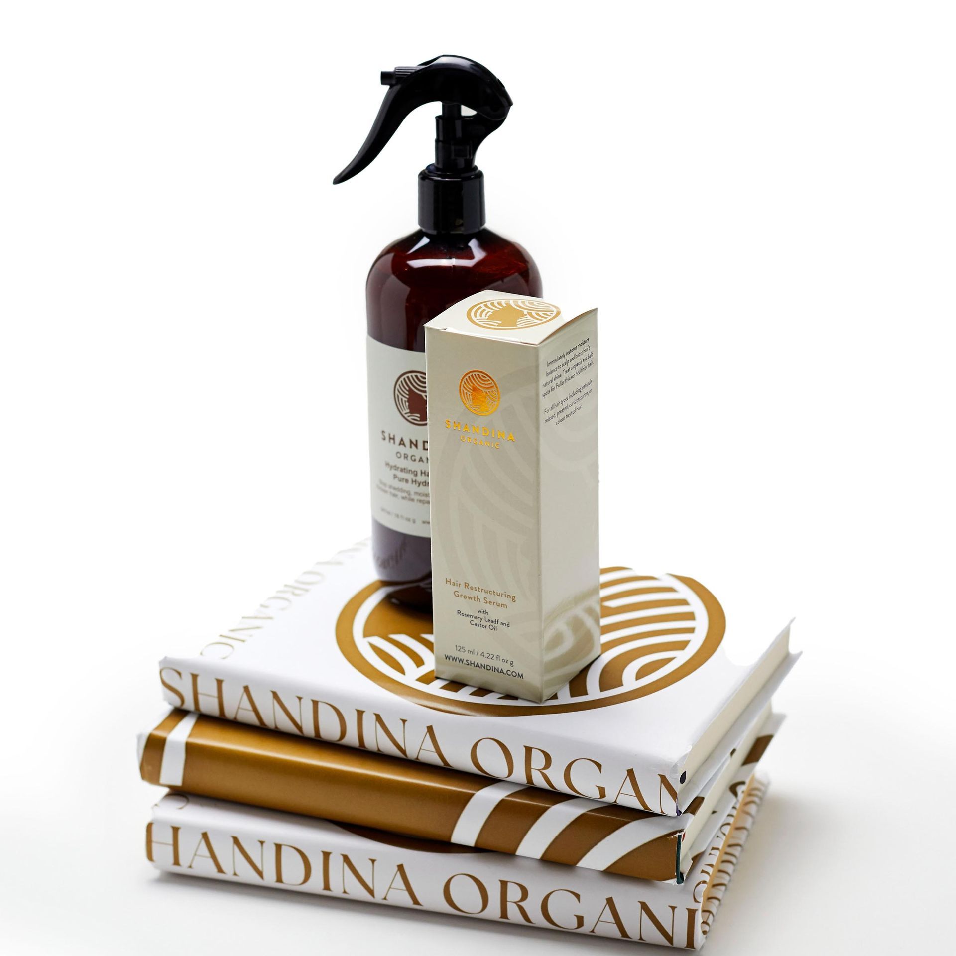 A stack of shandina organ books with a spray bottle and a box on top