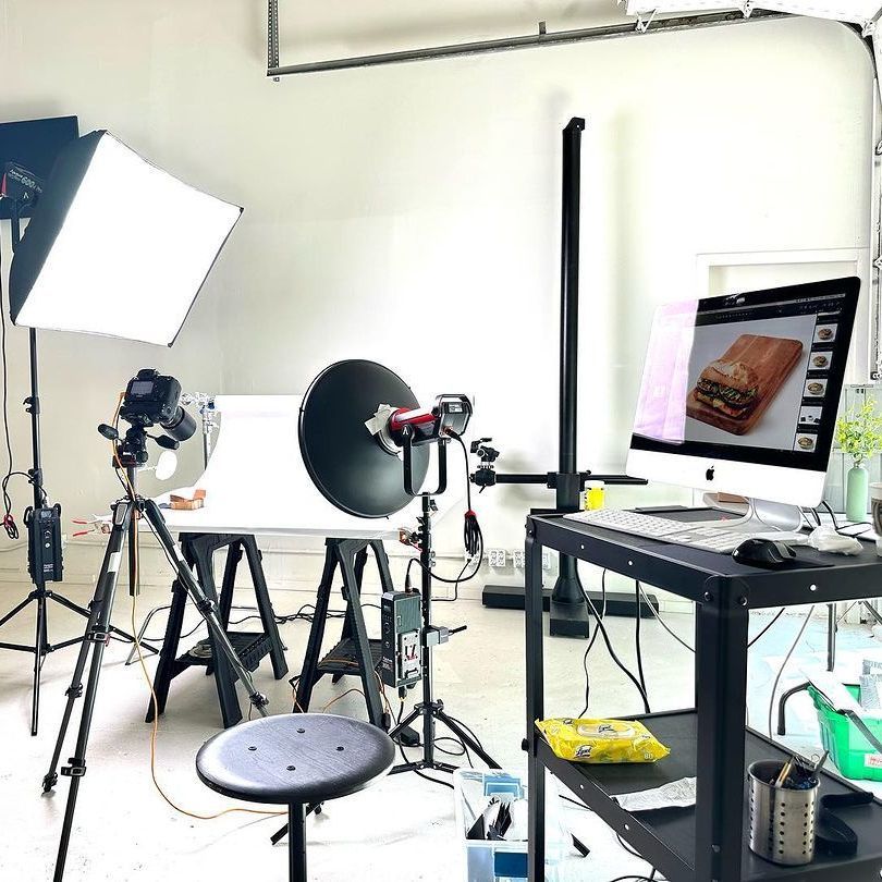 A photo studio with a computer and a stool