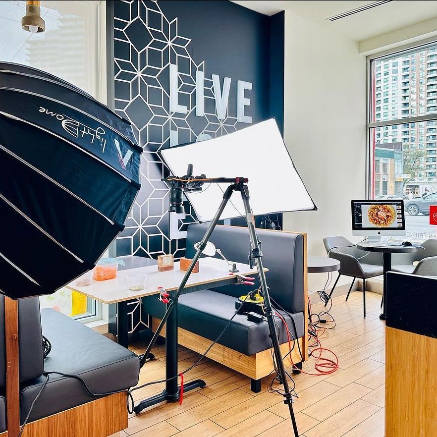 A photoshoot setup at a restaurant with a sign that says live on the wall