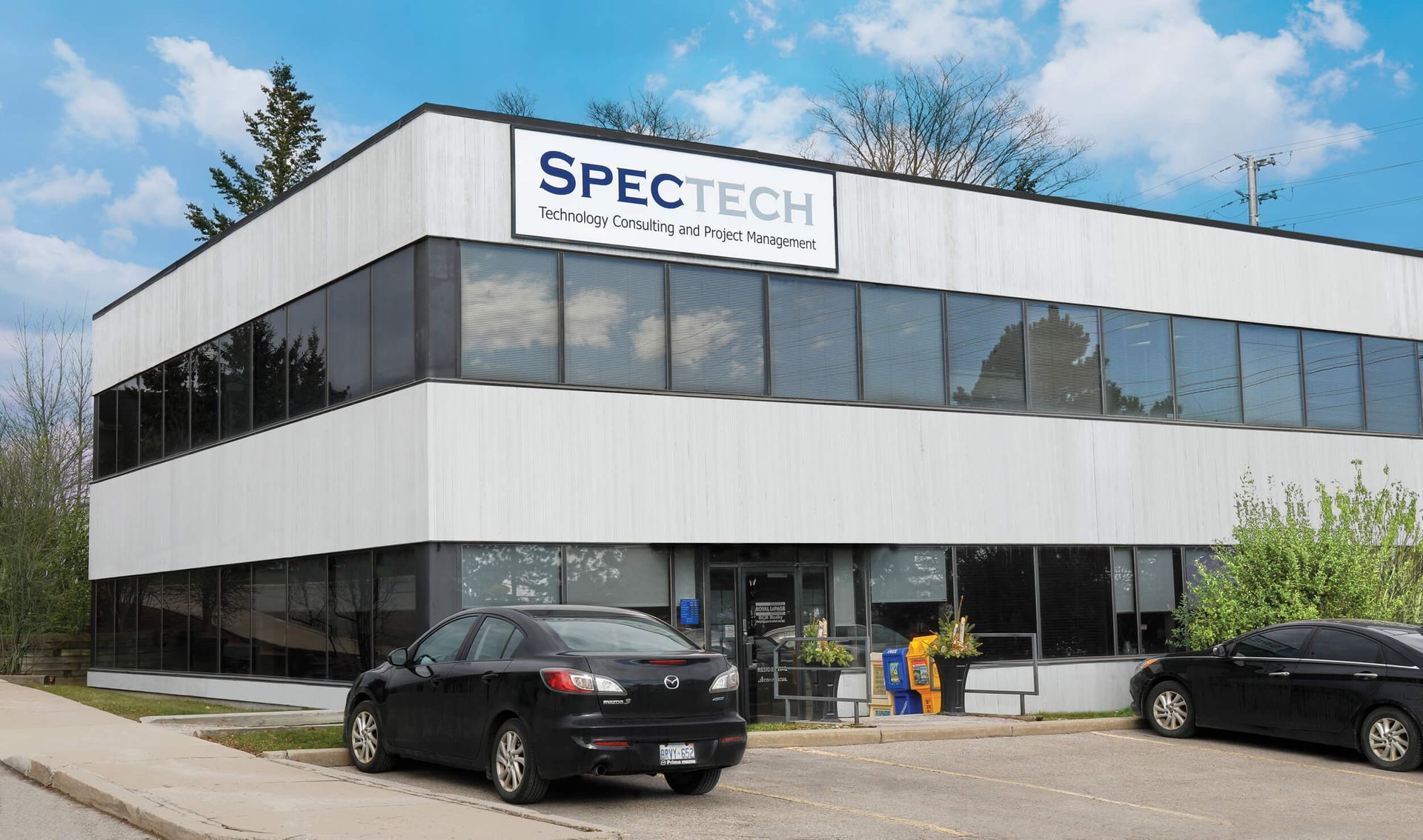 A spectech building with cars parked in front of it