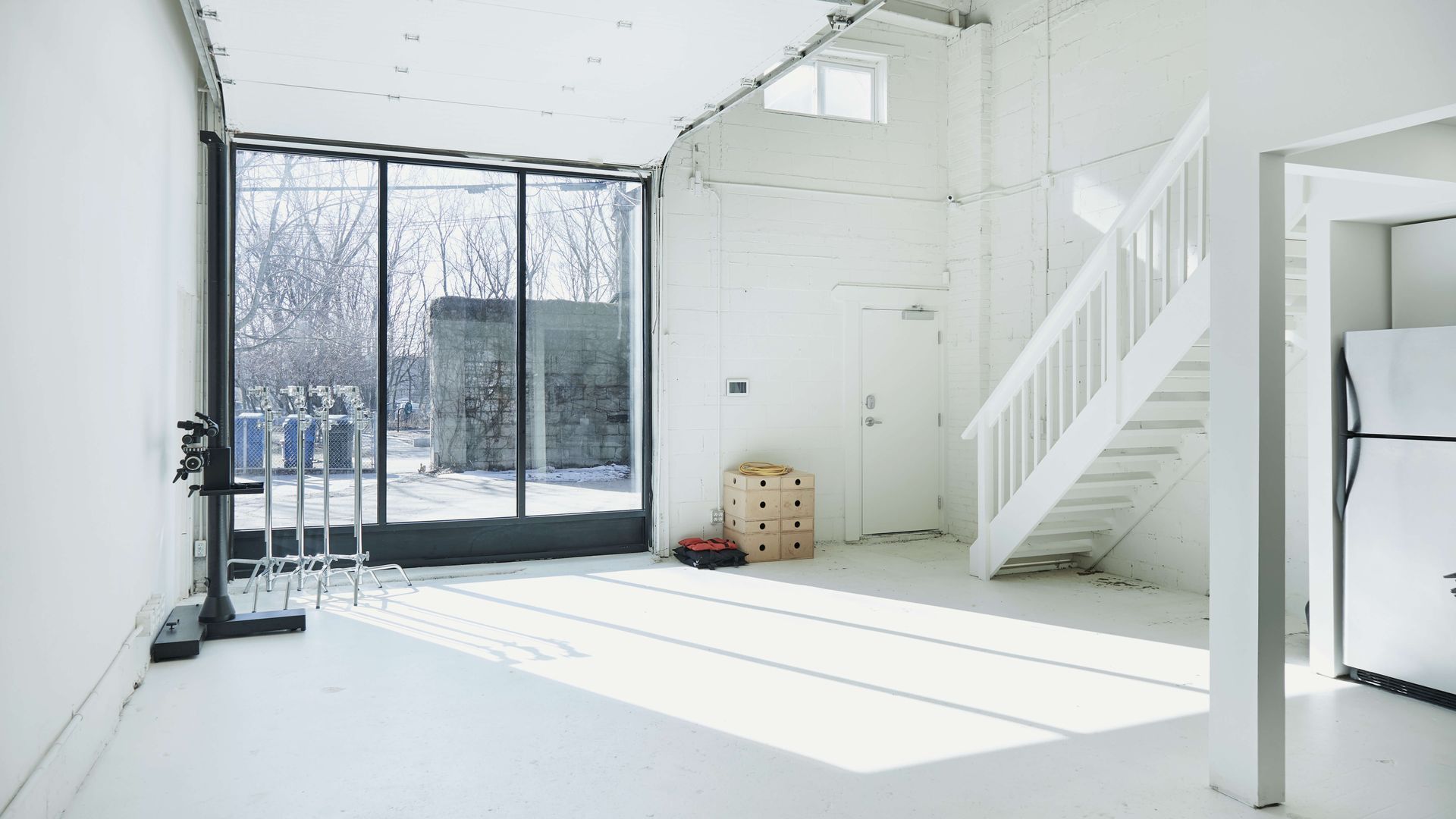 Bright open photo studio with a staircase in the middle of the room.