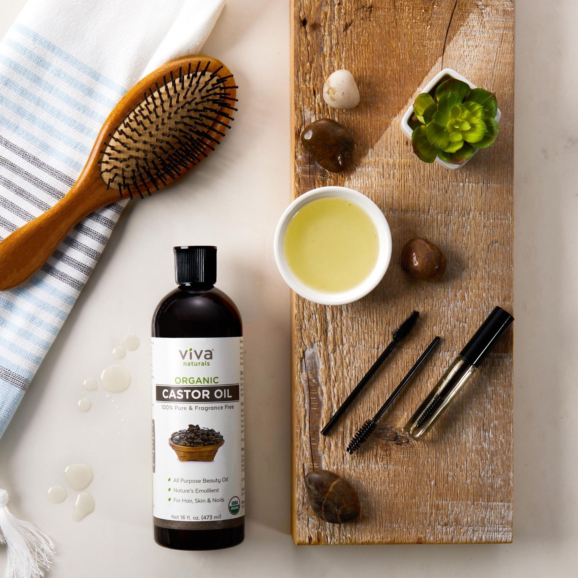 A bottle of castor oil sits on a wooden cutting board