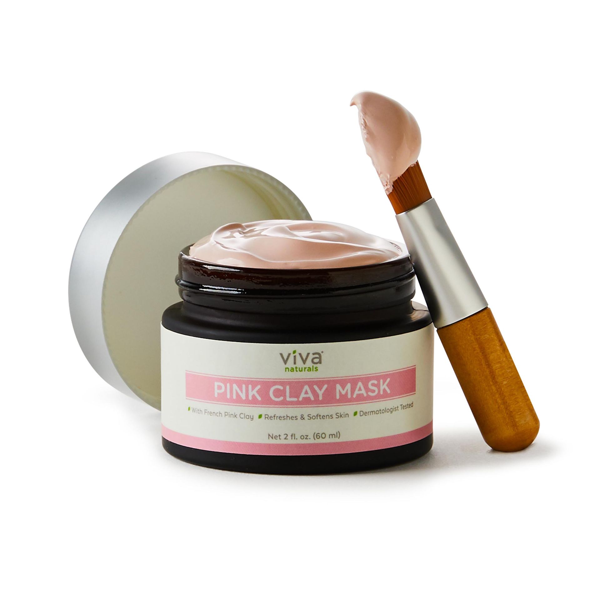 A jar of pink clay mask with a brush next to it