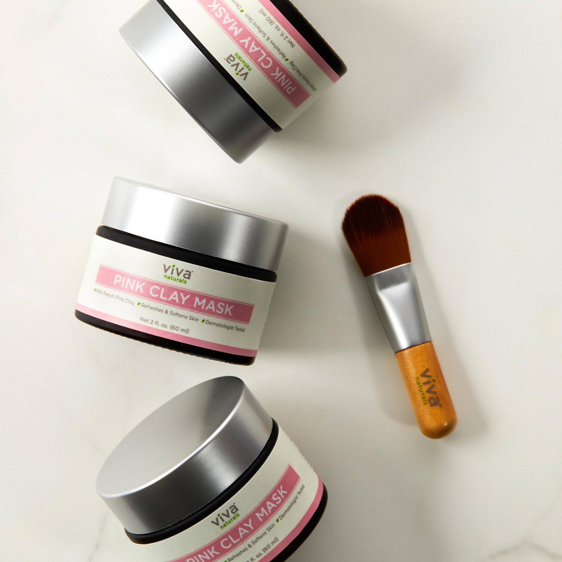 Three jars of pink clay mask and a brush