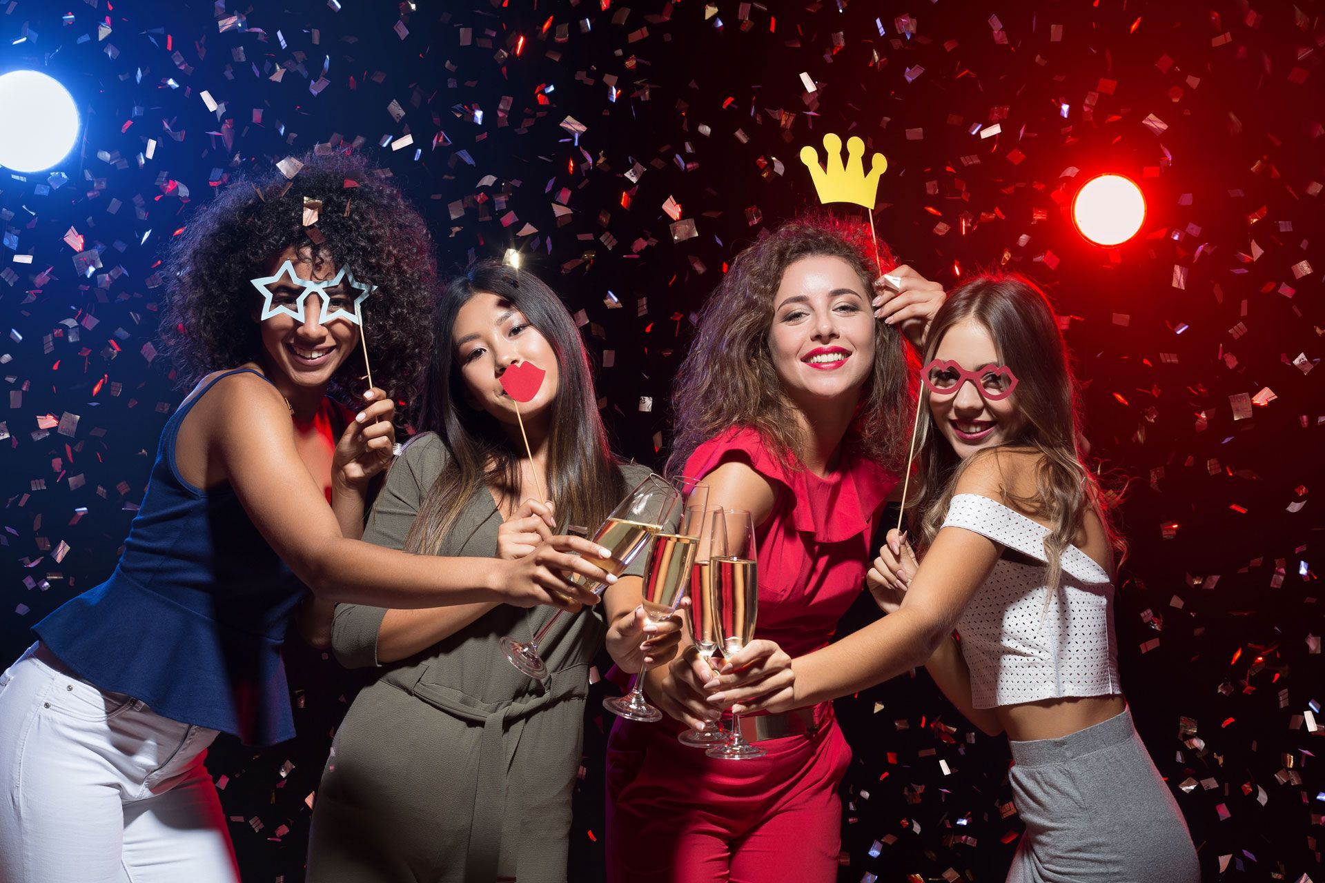 A group of women are holding champagne glasses at a party.