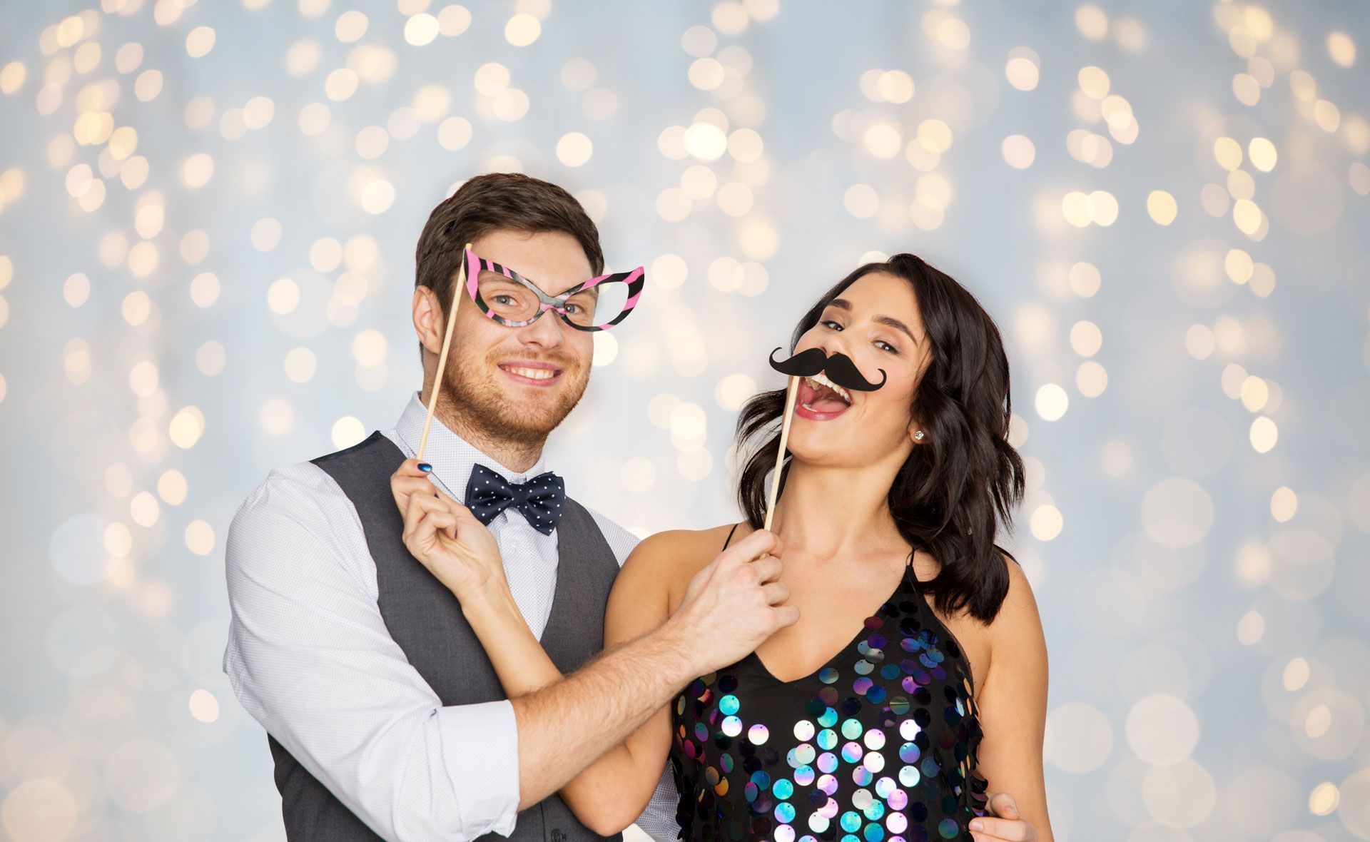 A man and a woman are posing for a picture with fake mustaches and glasses