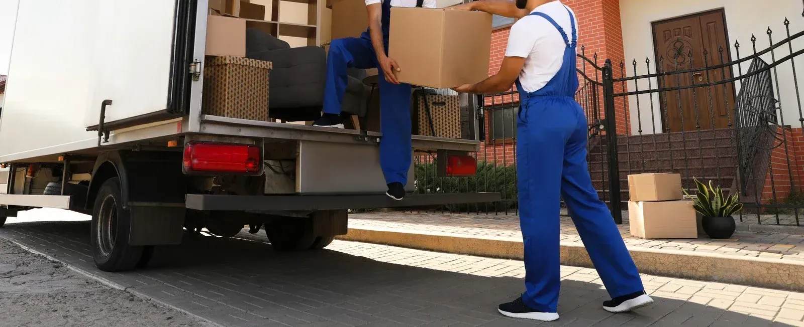 Two men are loading boxes into a moving truck.