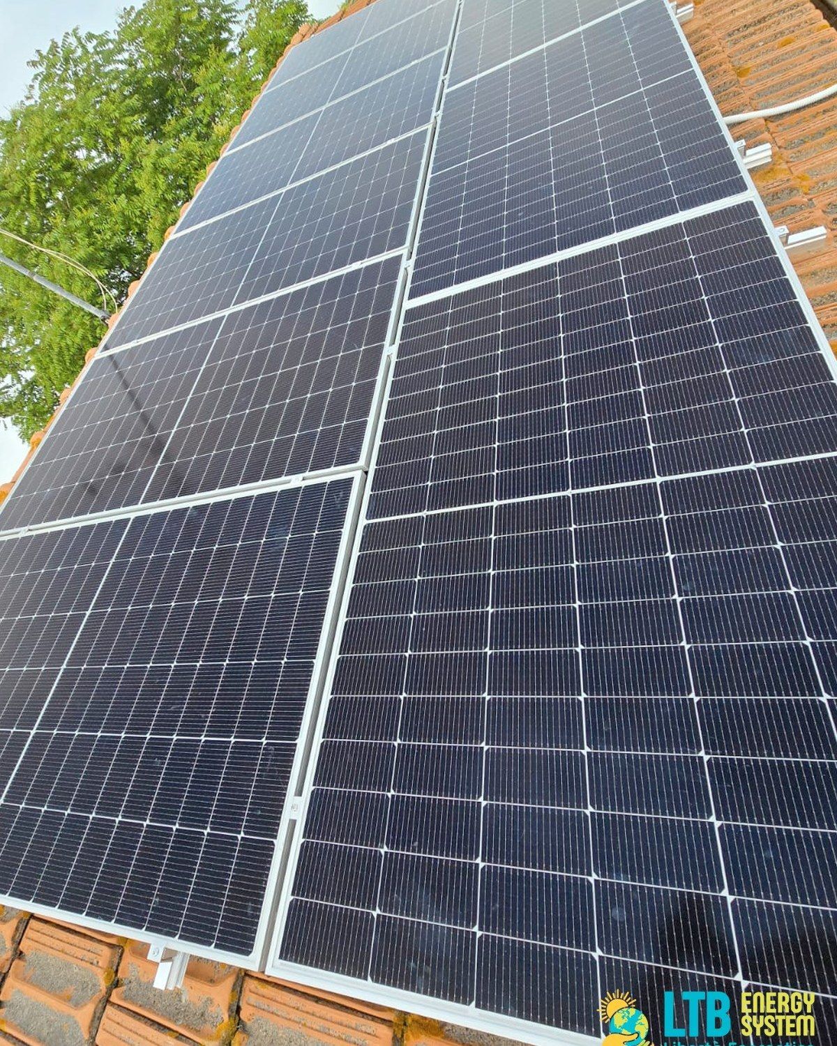 Pannelli solari installati su un tetto di tegole rosse, che assorbono la luce solare.