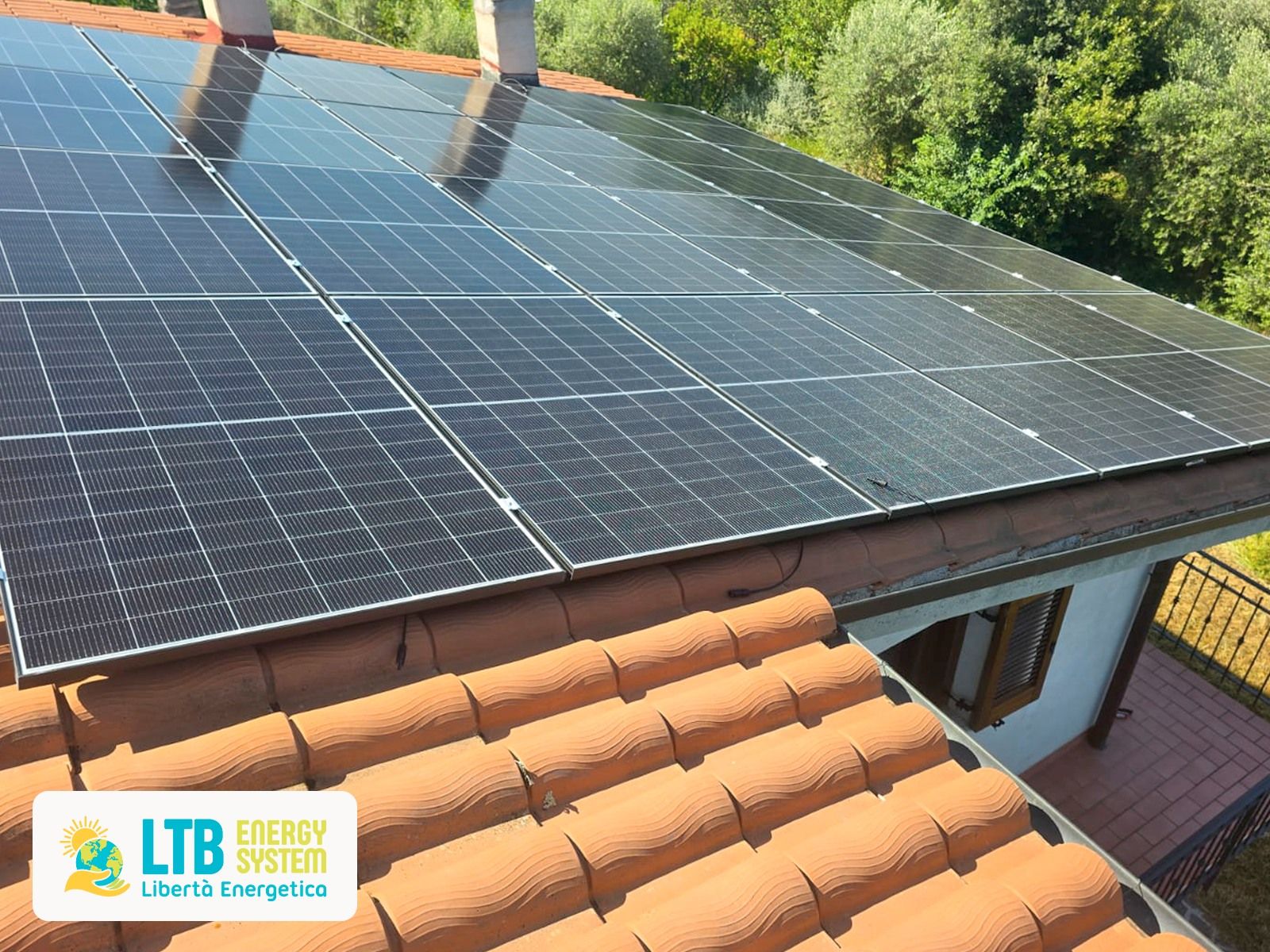 Pannelli solari installati su un tetto in tegole di terracotta. Il logo di