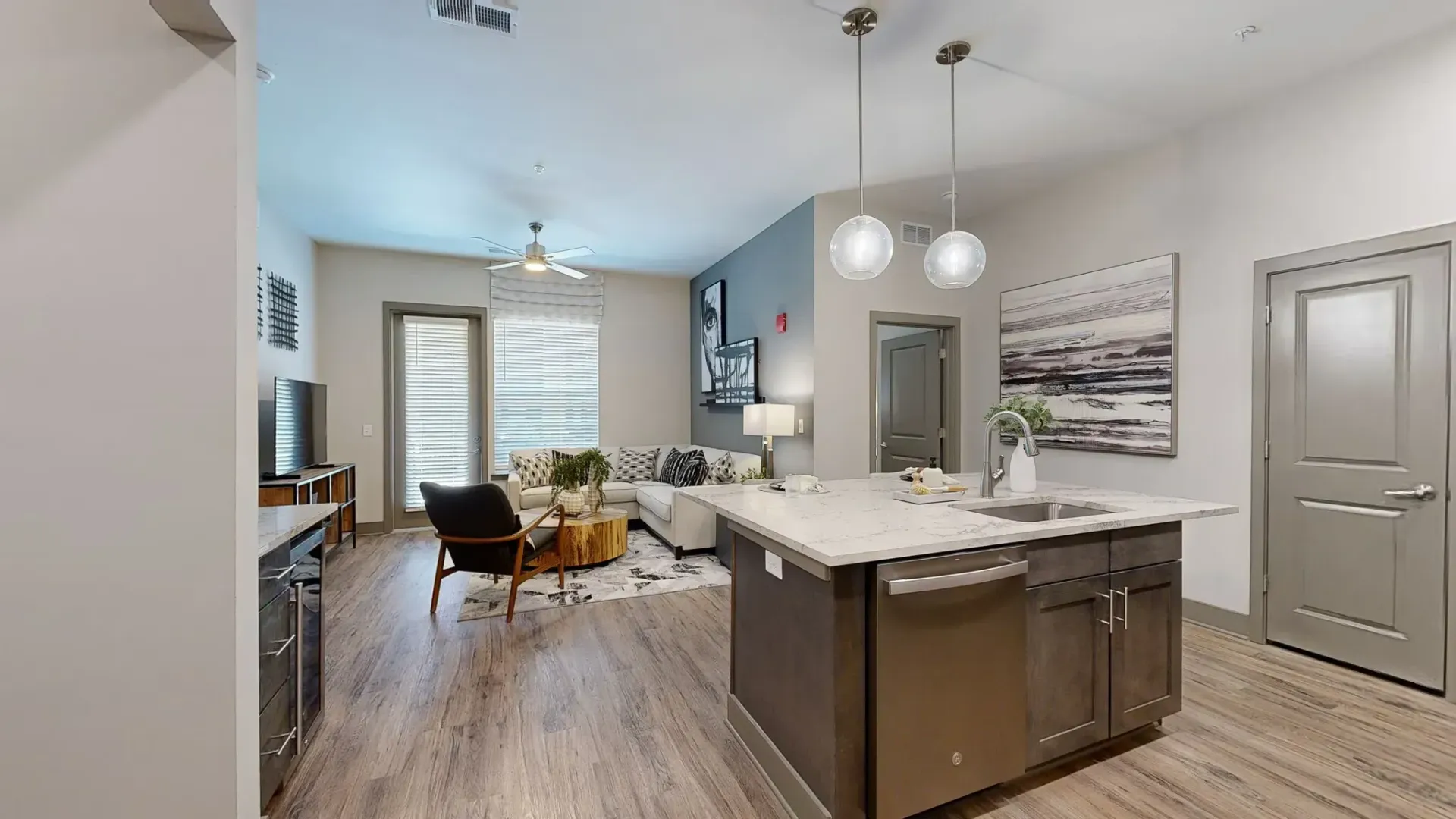 Open-concept living room and kitchen with island in a modern apartment.