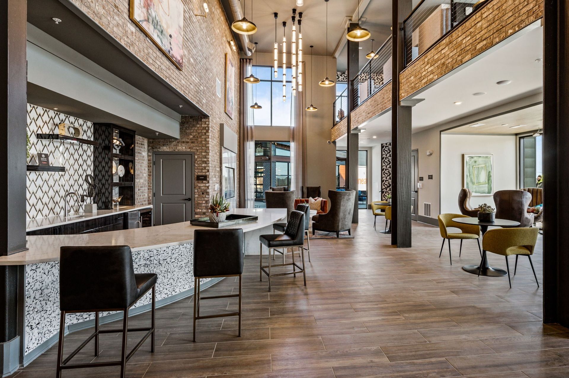 Modern residential community lounge with a long bar counter and seating area.