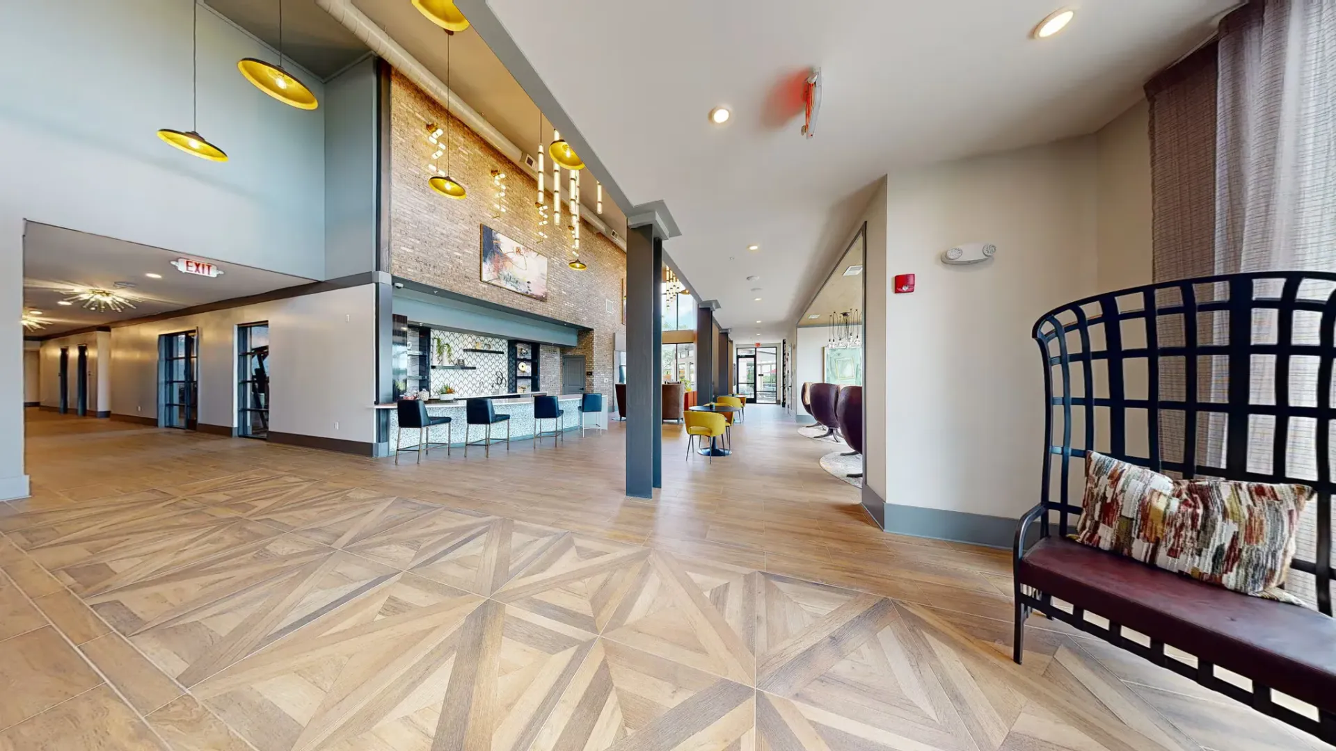 Spacious modern lobby with seating, bar area, and pendant lighting.