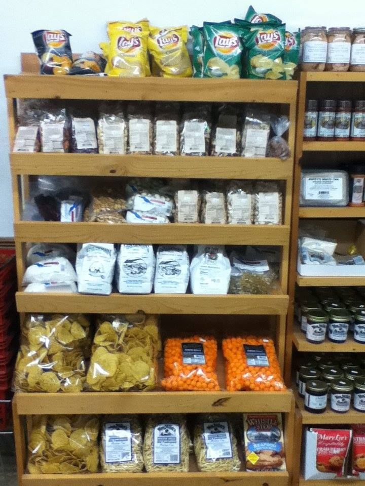 A store shelf filled with lots of snacks including lay 's chips