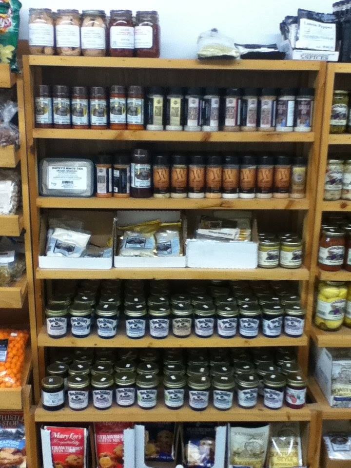 A store shelf filled with jars of jam and condiments