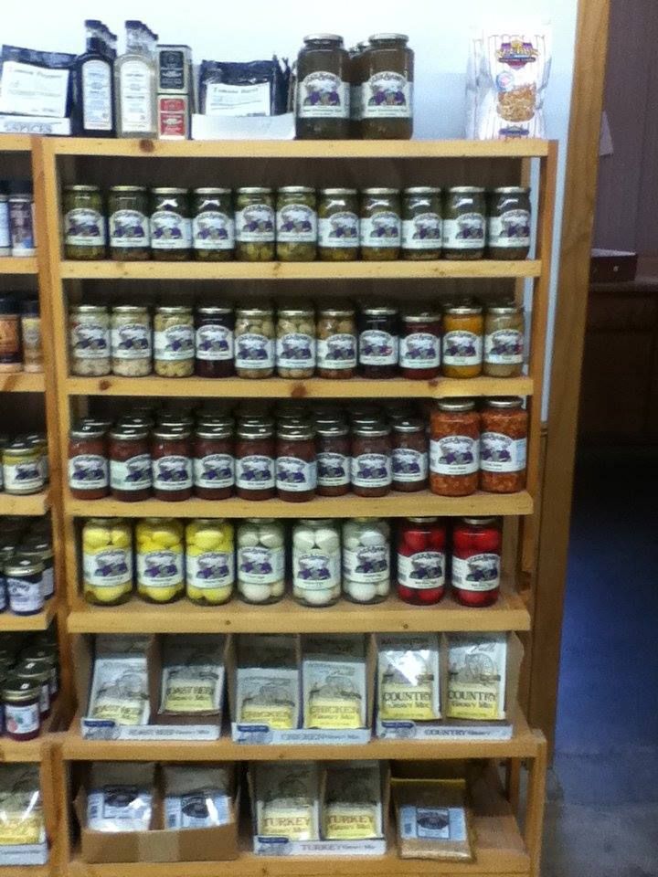 A wooden shelf filled with jars of various condiments