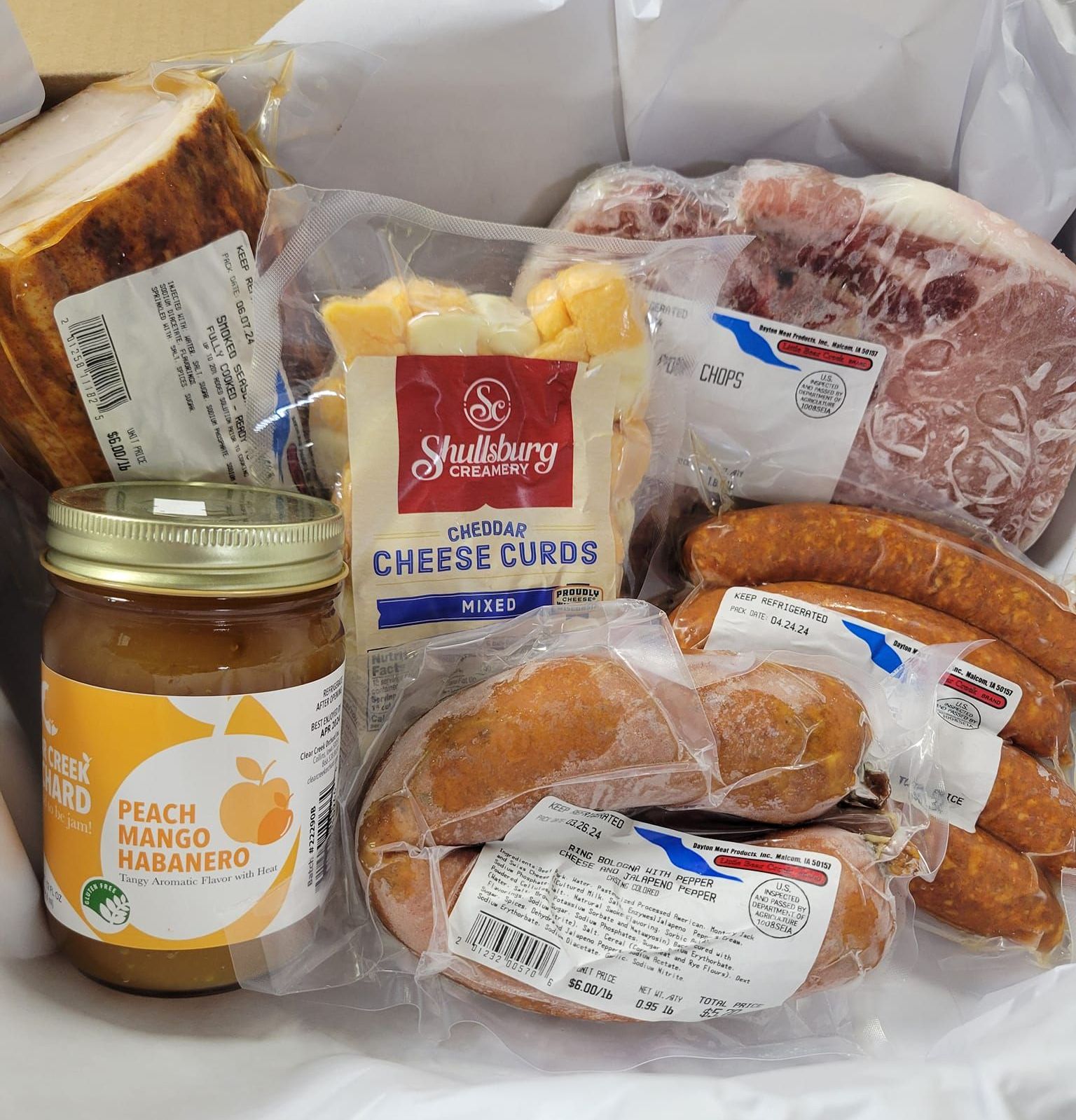 A variety of meats and cheeses including peach habanero cheese curds