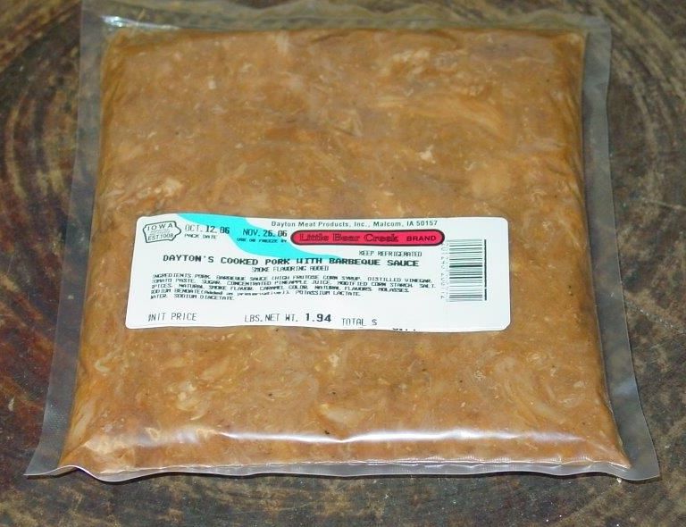 A bag of ground beef sits on a wooden table