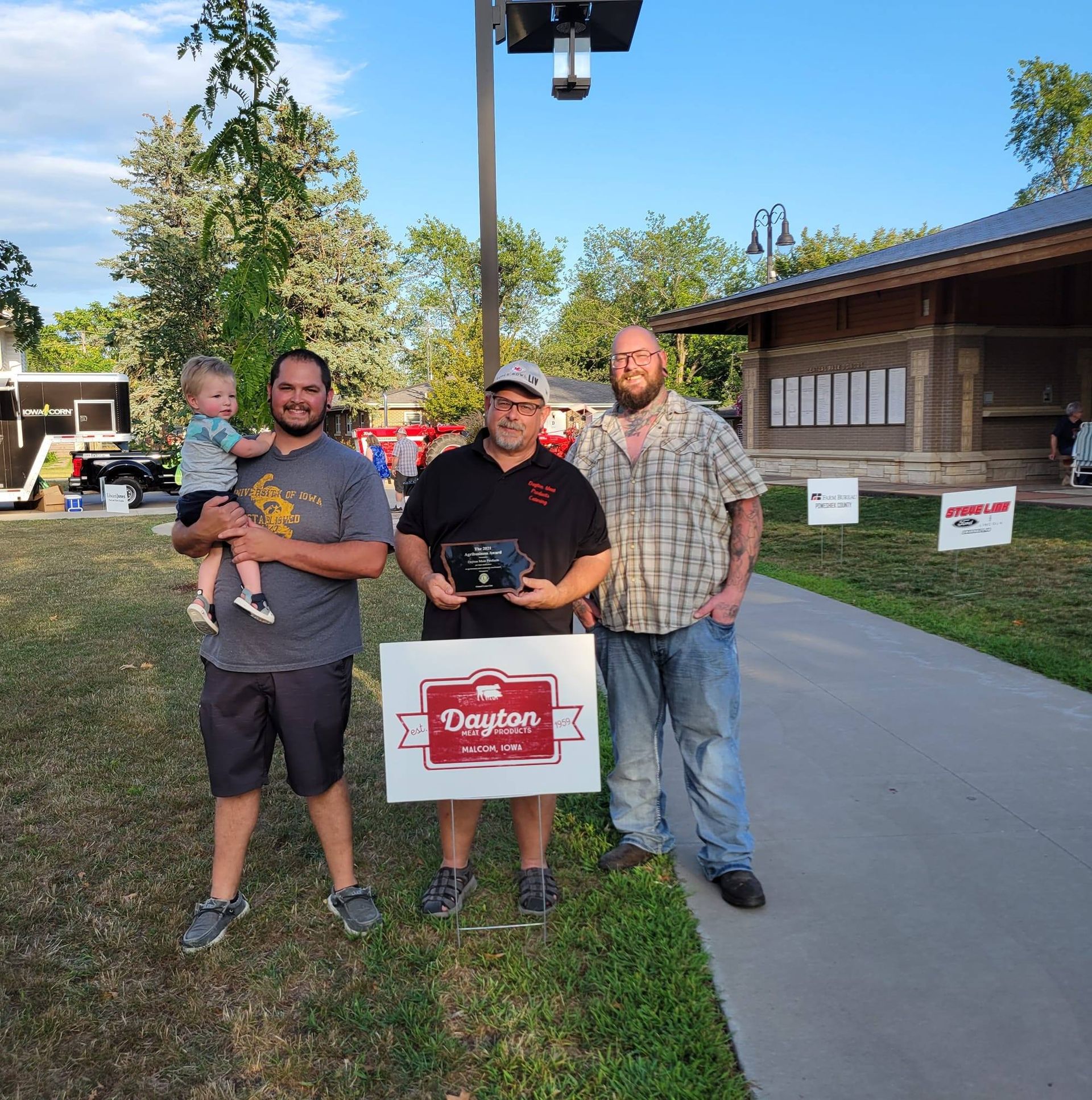 Three men standing next to each other holding a sign that says daytas
