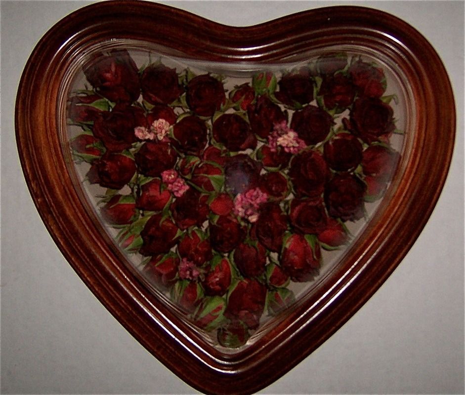 Heart-shaped wooden box filled with red strawberries on a light surface