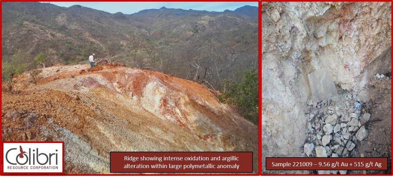 A man is standing on top of a hill next to a pile of rocks.