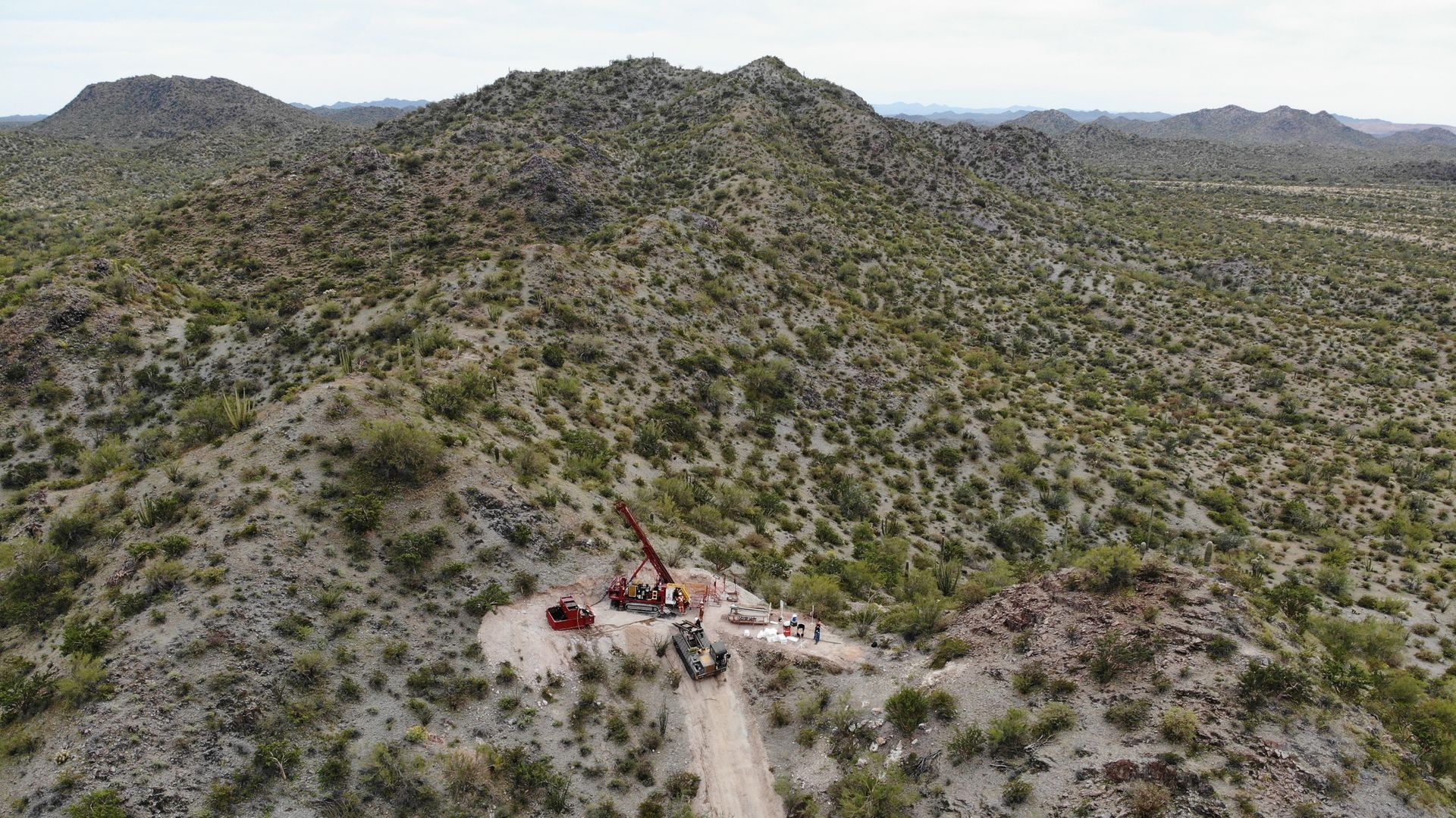An aerial view of a desert landscape with mountains in the background.