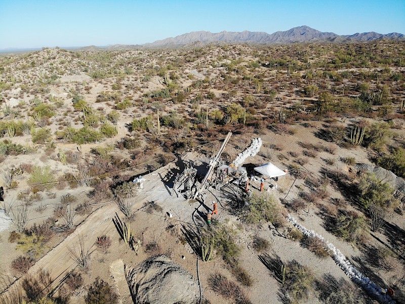 An aerial view of a desert landscape with mountains in the background.