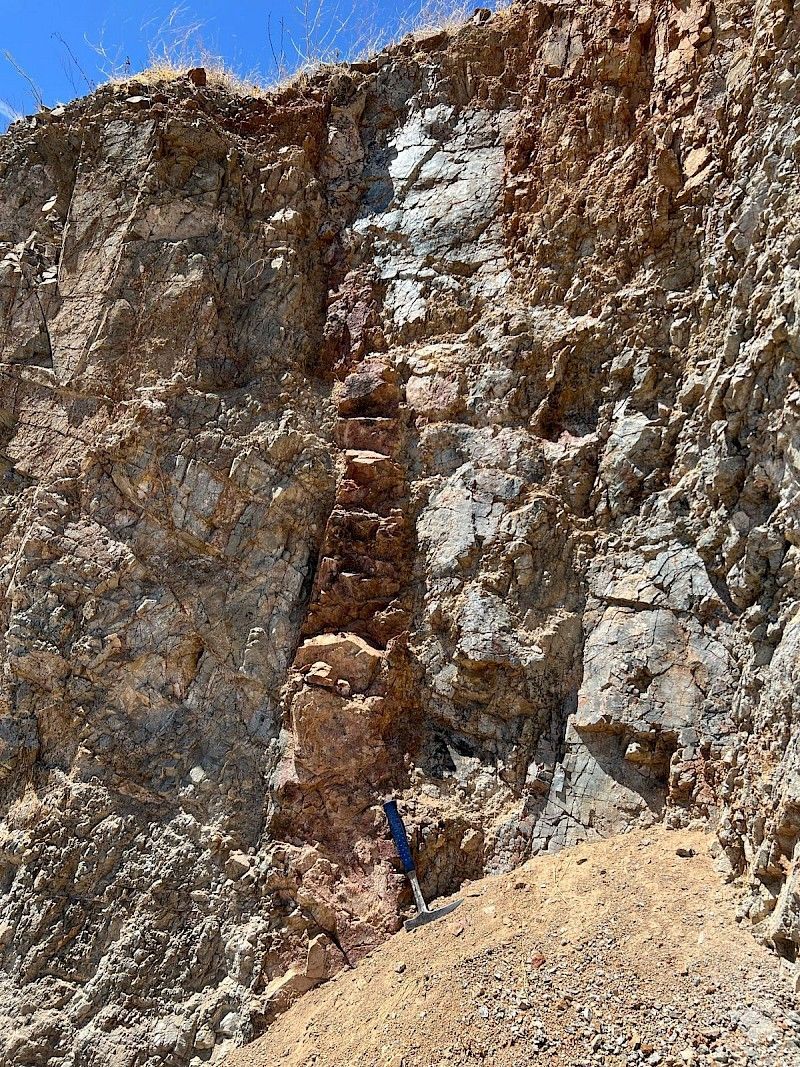 A person is standing on the side of a rocky cliff.