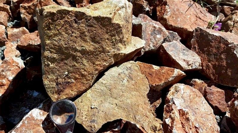 A glass of water is sitting on top of a pile of rocks.