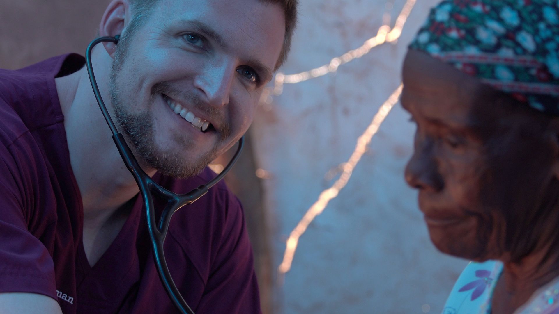 A man is using a stethoscope to listen to a woman 's heartbeat.