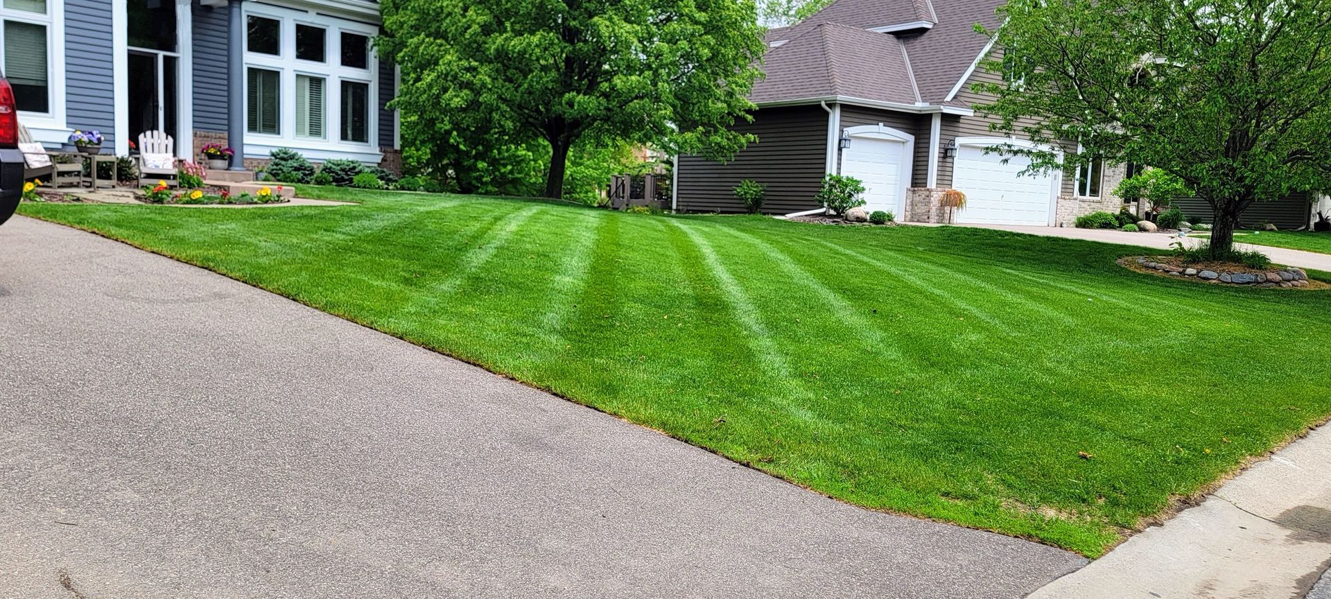 A lush green lawn is being mowed in front of a house.