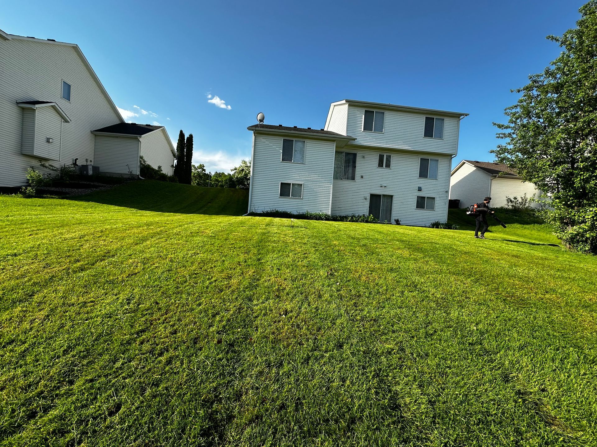 A white house sits on top of a lush green hillside