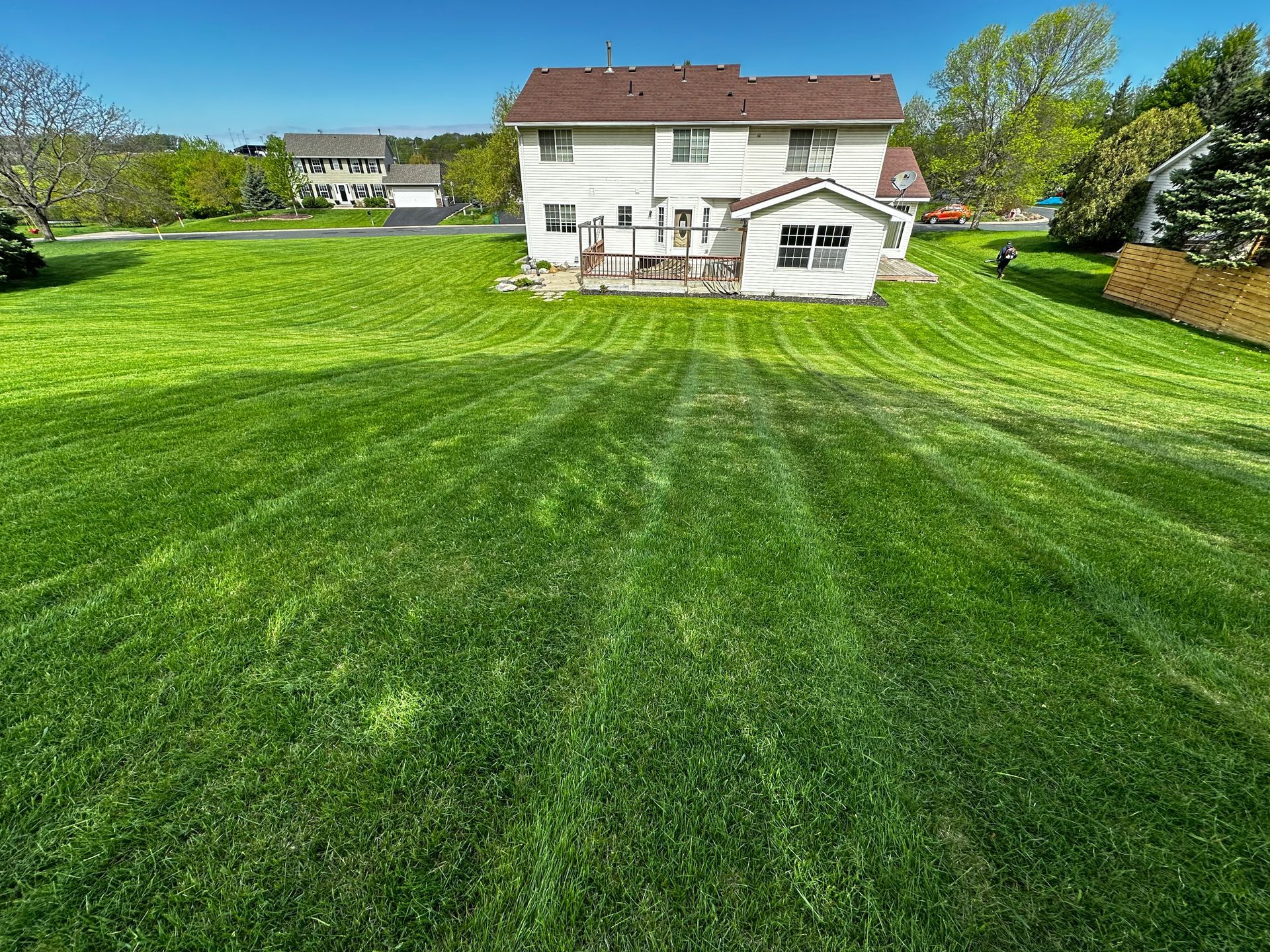 A large lush green lawn in front of a house.