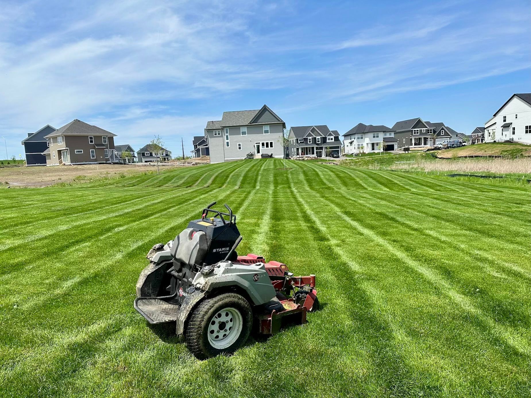 A lawn mower is sitting in the middle of a lush green field.