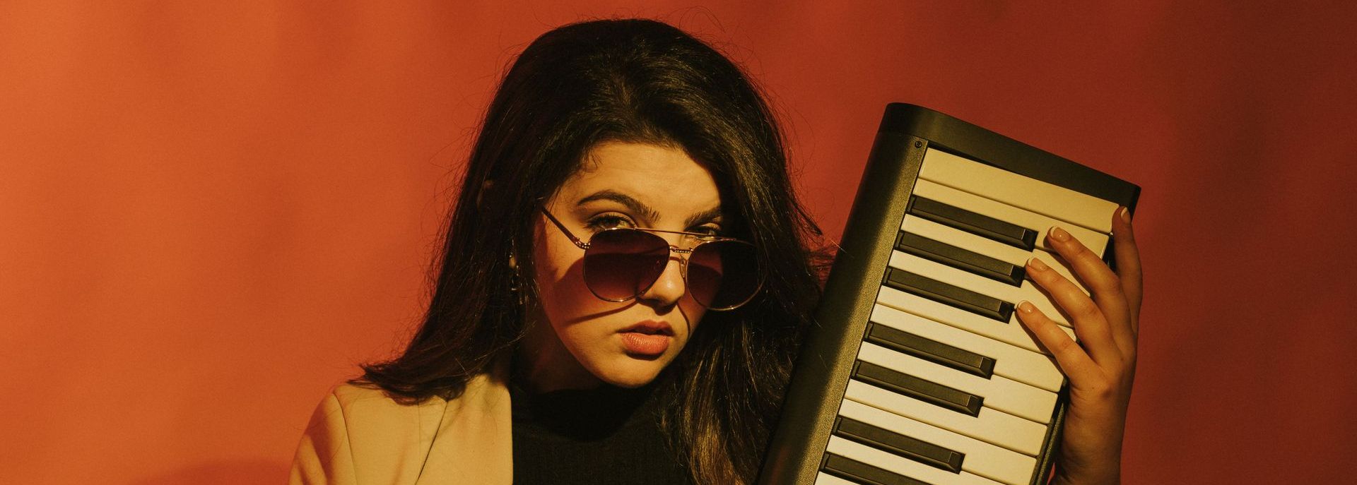 headshot of The Only Arena wearing sunglasses and holding an electric keyboard